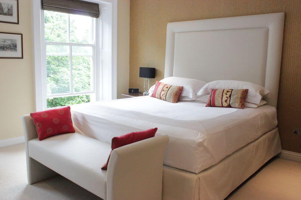 Bedroom with bespoke Upholstered Head Board and Ottoman